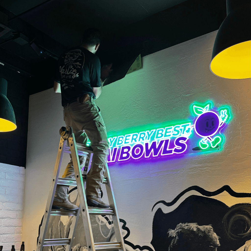 Jesus Enriquez of Vale City Electric diagnosing LED signage issue on ladder at Berry Berry Best Acai Bowls in North Phoenix